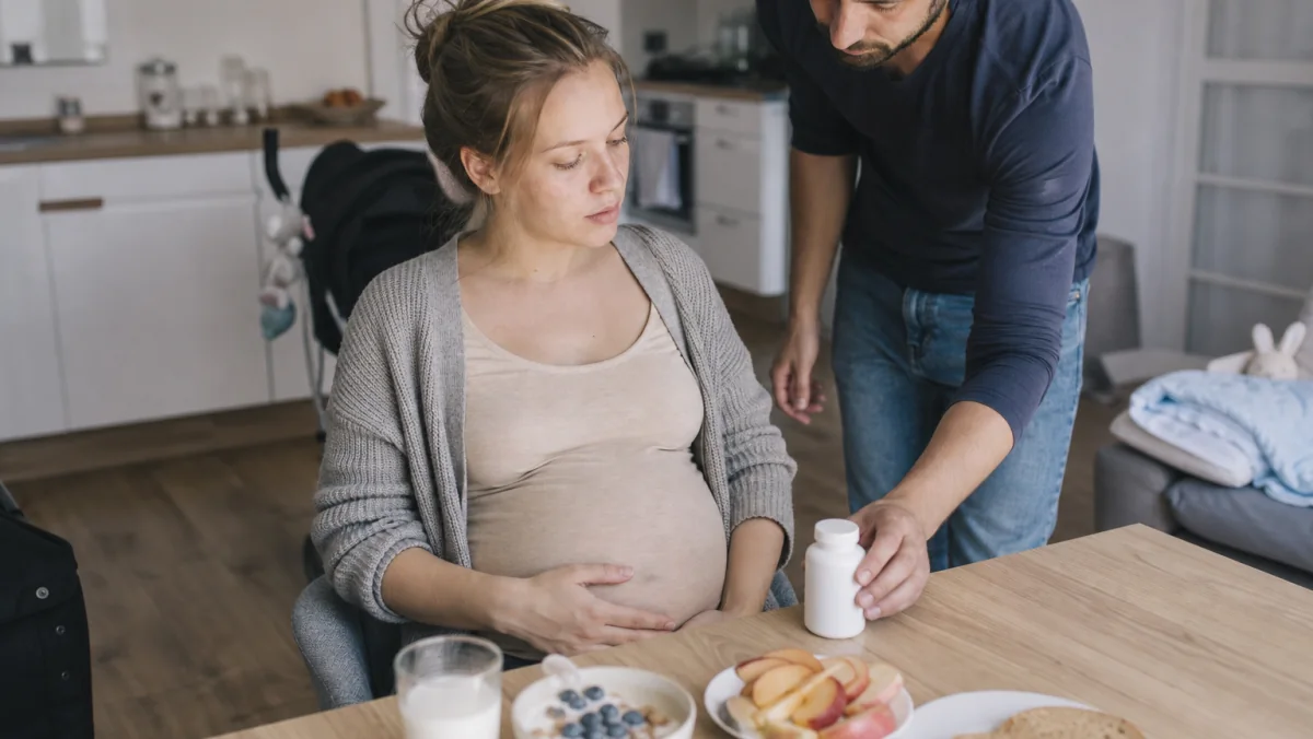 Trudnica uzima prenatalne vitamine uz zdrav obrok kod kuće